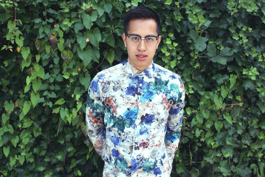 Steven Phan standing in front of lush green background wearing a floral shirt 