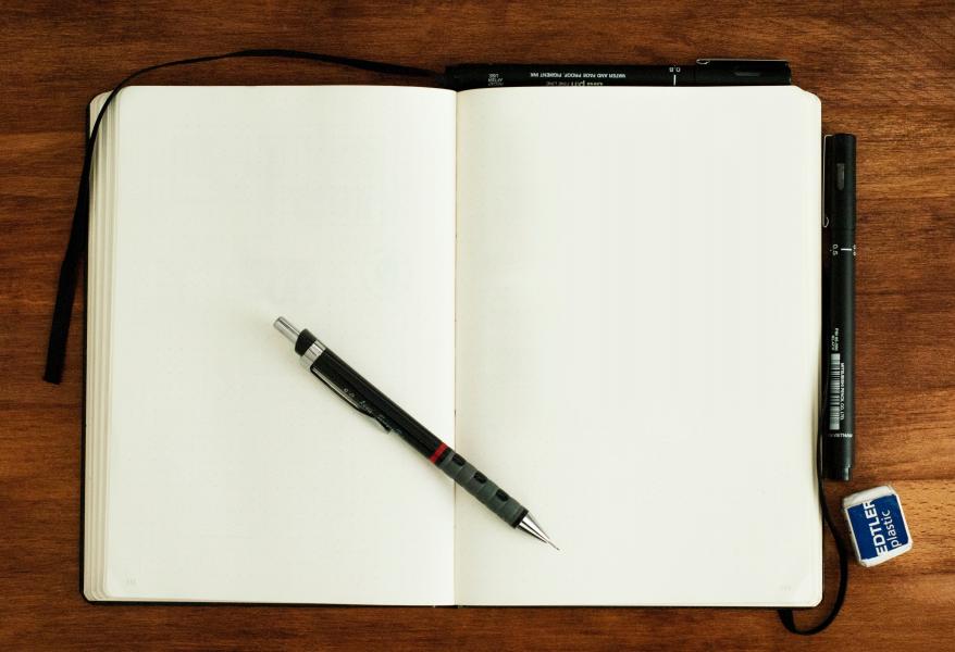 blank notebook with a pen on top