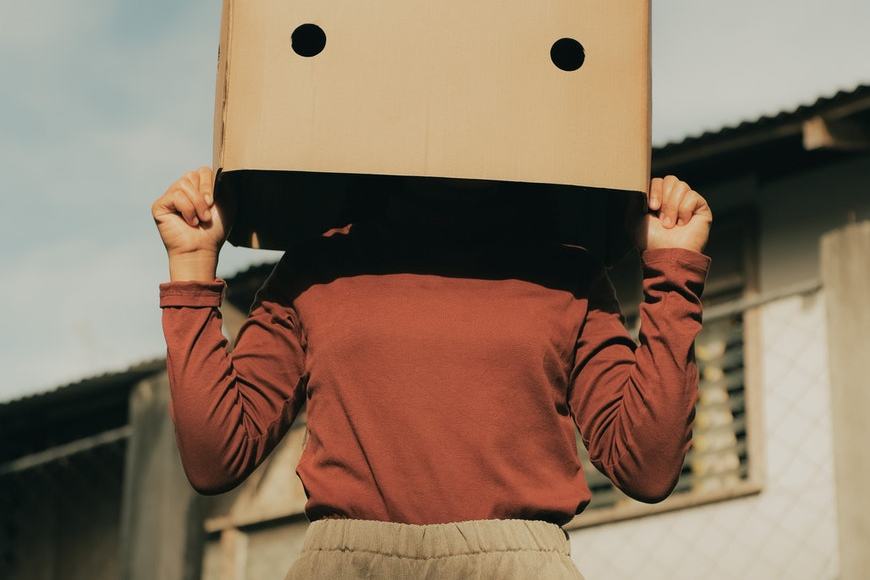 A woman standing with a cardboard box on her head