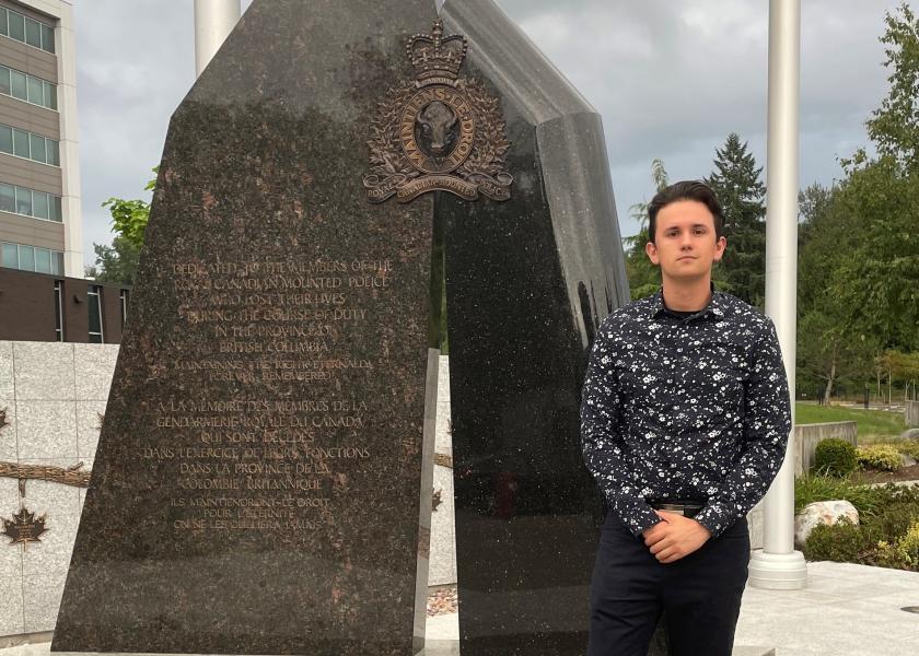 Picture of Ivan standing in front of a memorial.