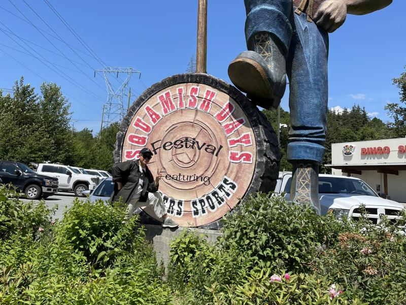 An image of Chloe Evangelista standing in front of a sign that says Squamish Days Festival, to commemorate a site visit to two Squamish Nation-owned businesses in Squamish, BC.