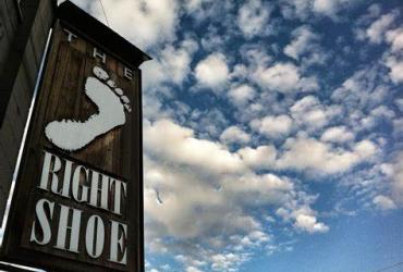 An image of the Right Shoe sign on the store exterior against a blue sky