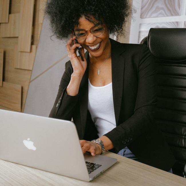 a woman in the office smiling on her phone