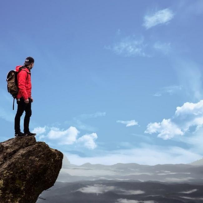 man standing on rock looking at sky