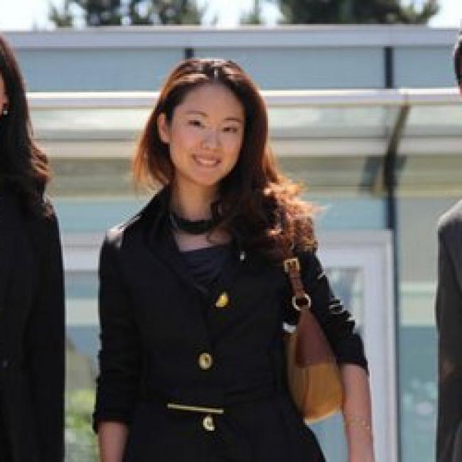 three people wearing professional attire standing side by side