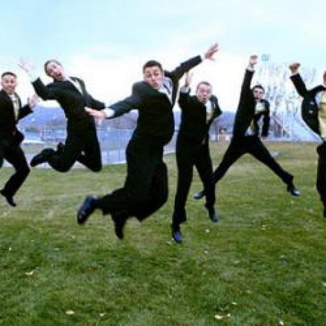 Multiple guys in suits jumping in unison