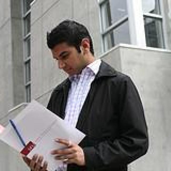 A man looking at a pile of resumes