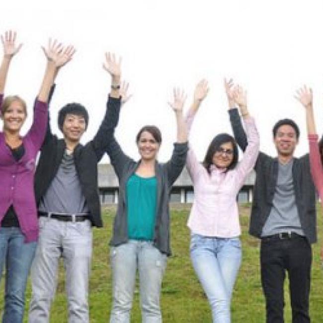 8 studnets standing in a line with their hands in the air celebrating