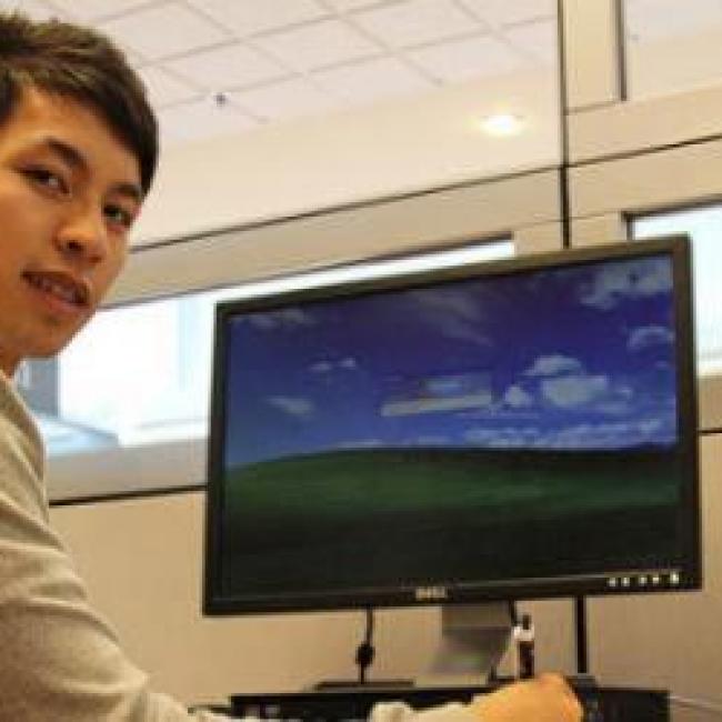 Picture of kenny yang working at a computer