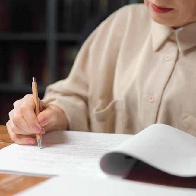 A person marking up a paper with a pen 