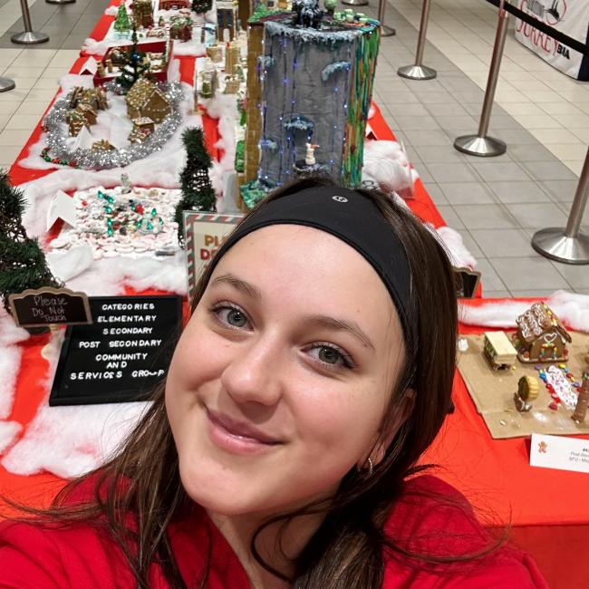 Girl posing with gingerbread village 