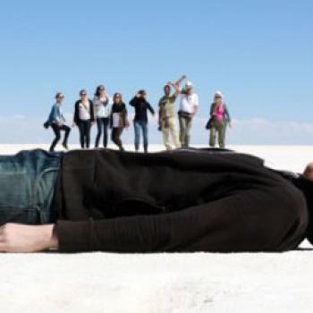 Image of a person lying down with people standing on top