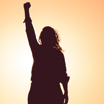 A silhouete of a woman with her fist raised