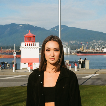A picture of Terae in front of mountains and a lighthouse. 