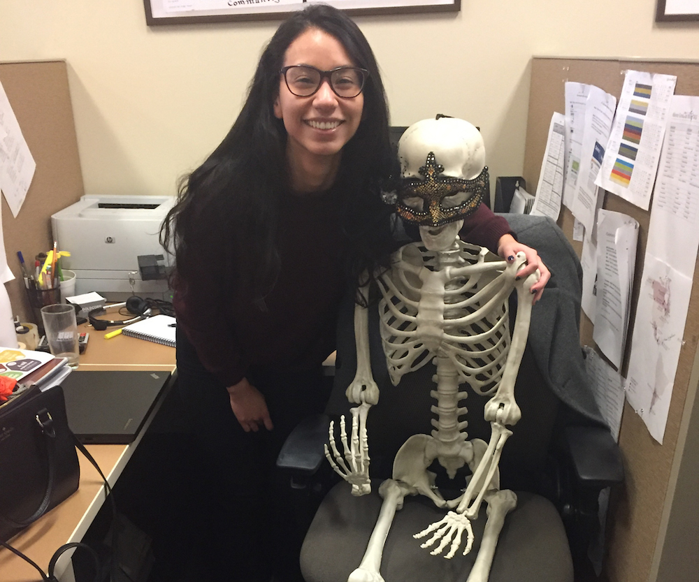 Joselyn posing next to a skeleton in her co-op office