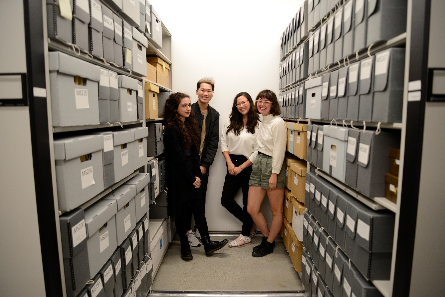 Rita, Aaron Tong, Lisa Uyeda and Reiko Pleau between the moving shelves housing manuscripts inside the vault.