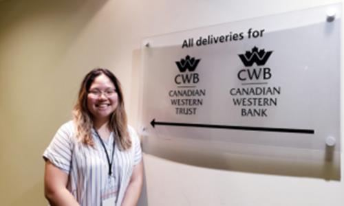 the author standing next to Canadian Western Bank logo 