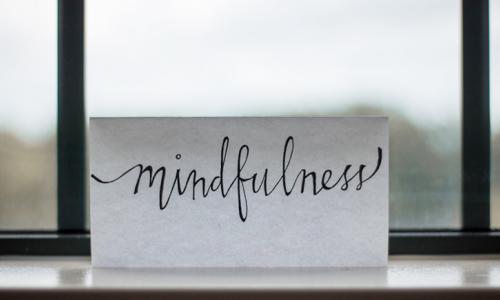 a letter placed on a windowsill with the text that says mindfulness