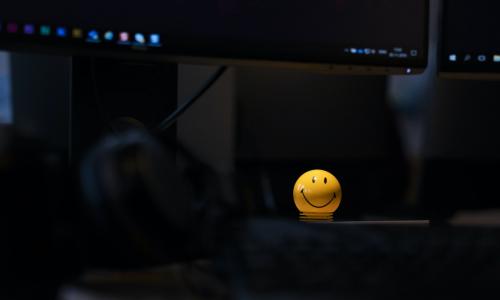 a yellow smiling face figure in a dark room