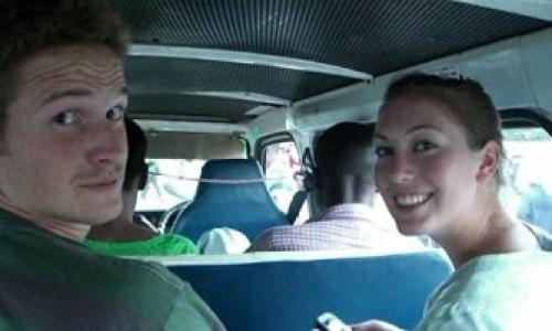 Two people in the bus smiling to the camera