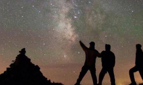 3 men watching the galaxy sky at night