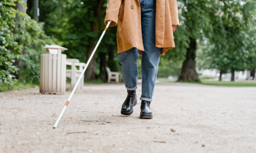 A person using a white cane on an outdoor path