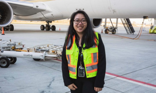 Mandy in a high visibility vest on the tarmac of YVR
