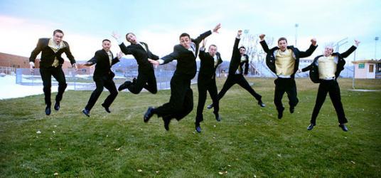 Multiple guys in suits jumping in unison