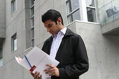 A man looking at a pile of resumes