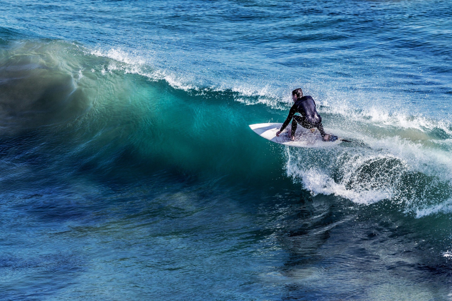 A person in a wetsuit surfing a wave.