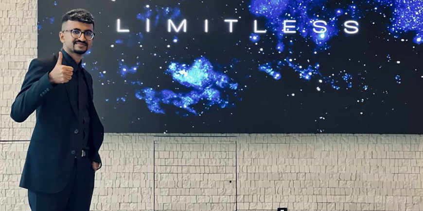 Abu standing next to a screen that says "Limitless"
