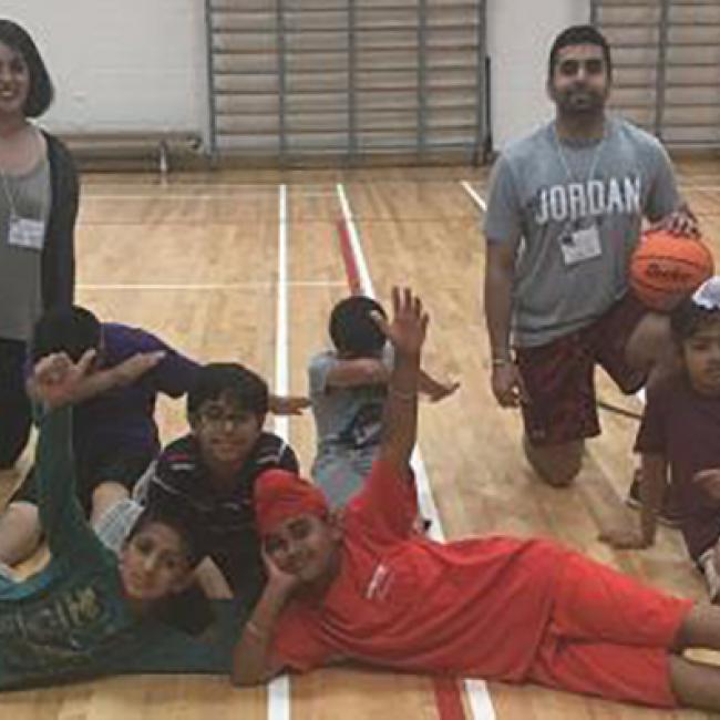 A photo of Racing Readers students and mentors at a basketball court 