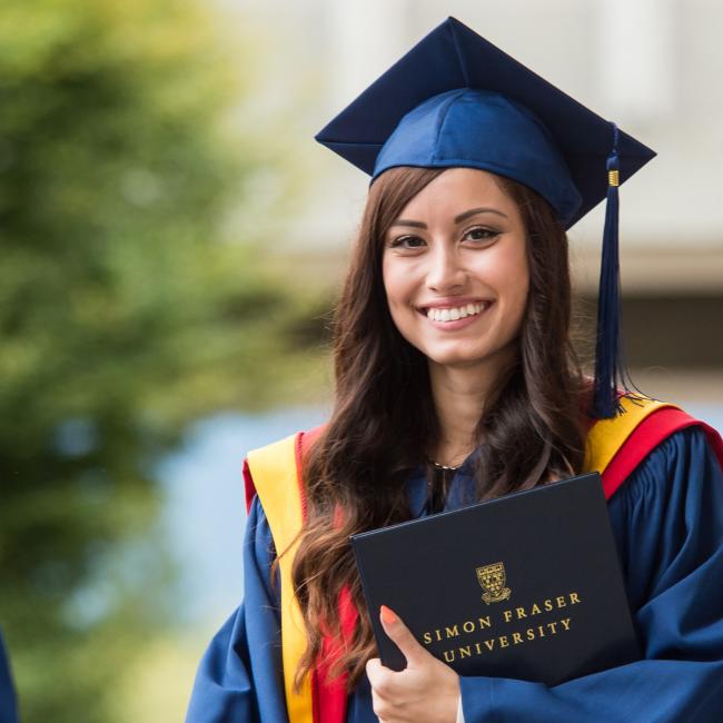 a SFU graduate during convocation holding her diploma