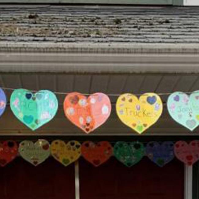 hand-drawn paper cut hearts strung across the roof of a house