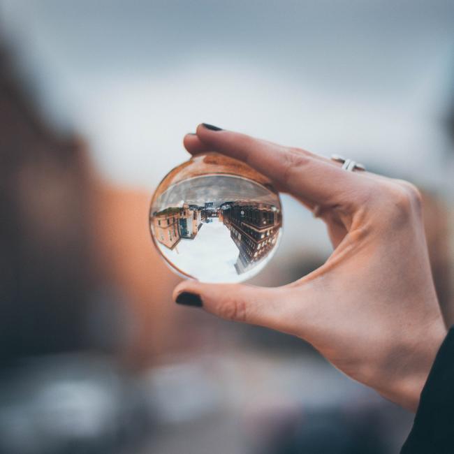 a different perspective by holding up a sphere against a background 