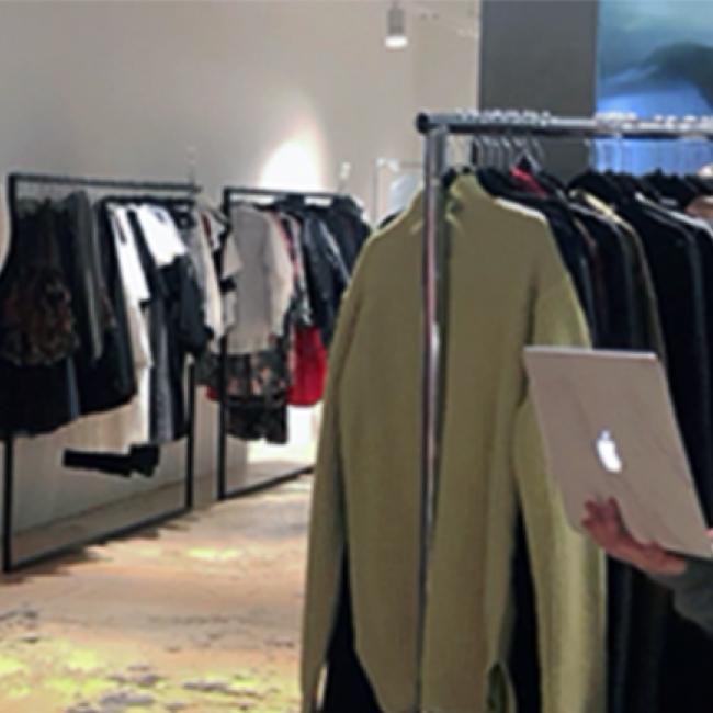 the author looking at her laptop in a fashion store