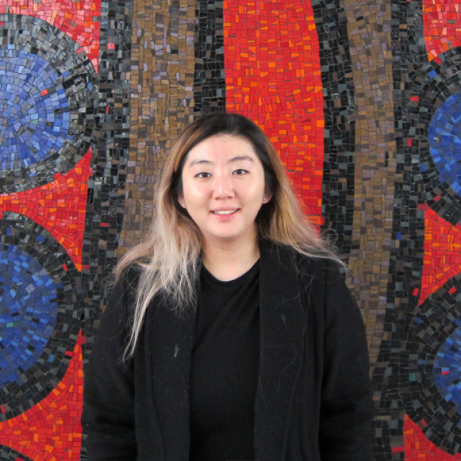 Image of Sarah Kim standing in front of a mural
