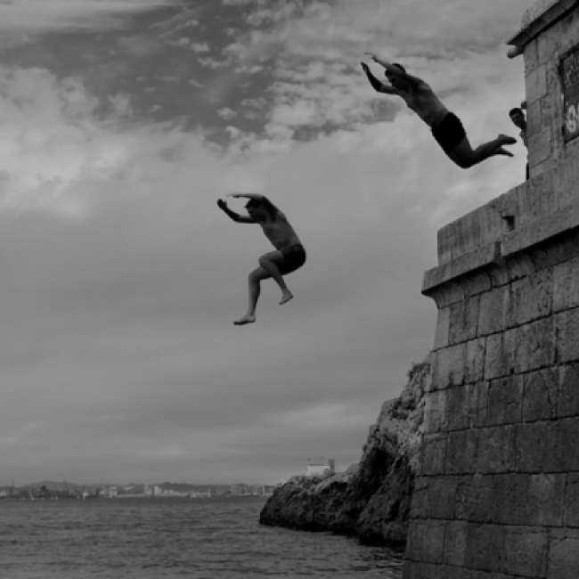 Men jumping off a cliff