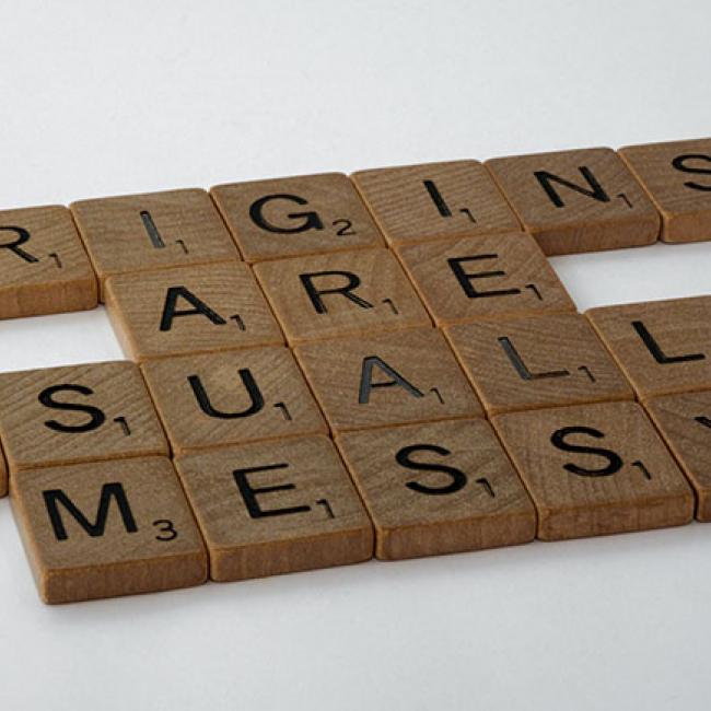 Scrabble Tiles spelling out the phrase "origins are usually messy"