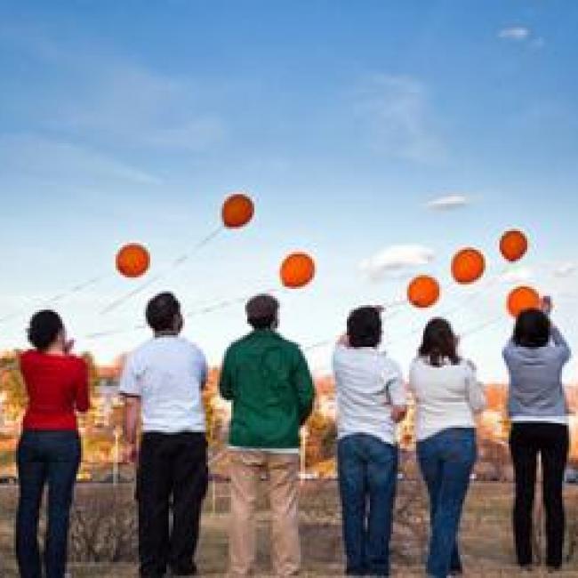 Group of people with balloons in the sky
