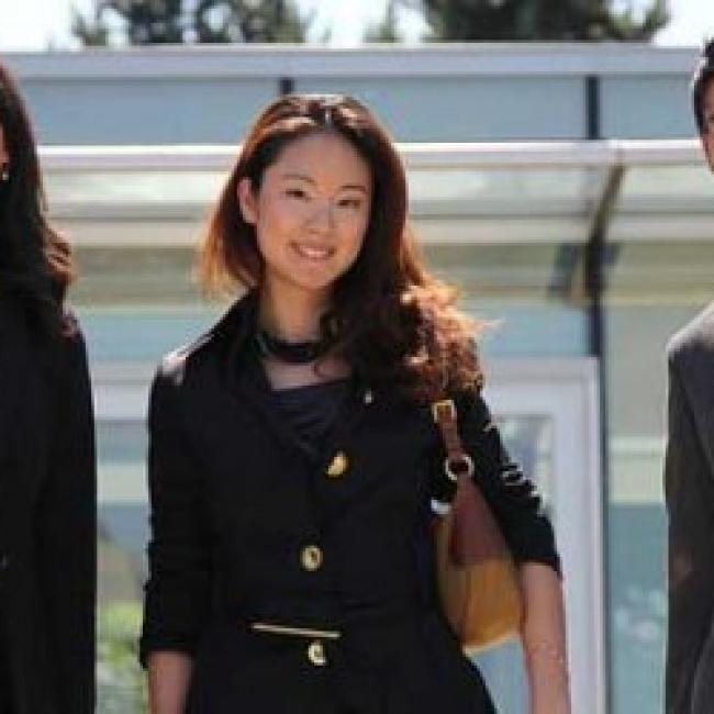 Three students standing in professional attire, side-by-side