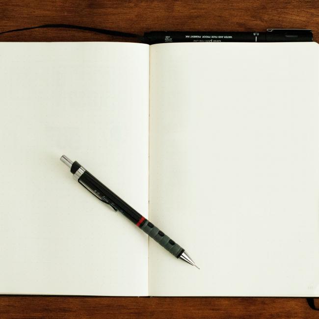 blank notebook with a pen on top