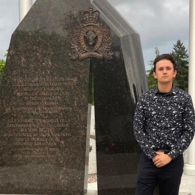 Picture of Ivan standing in front of a memorial.
