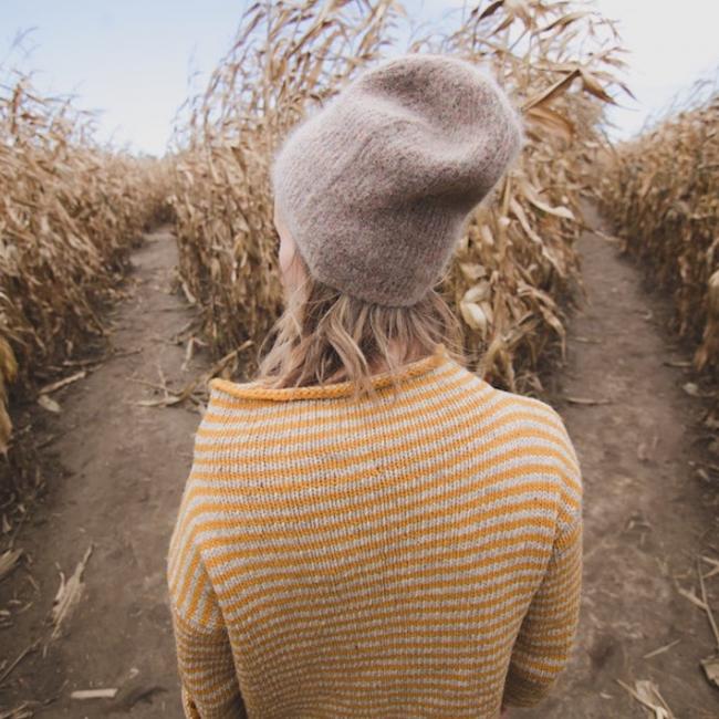 A person standing at a crossroads in a corn maze
