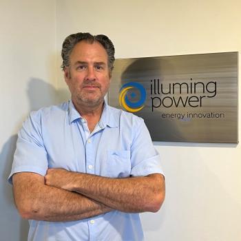 Picture of Mike standing by Company Logo