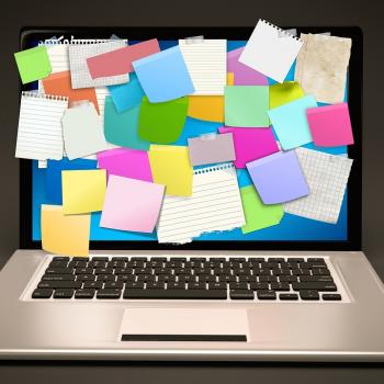 Open laptop with colourful post-it notes covering the screen